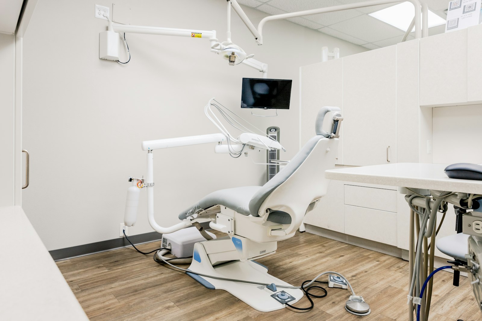 An empty dental exam room with the chair and lights ready